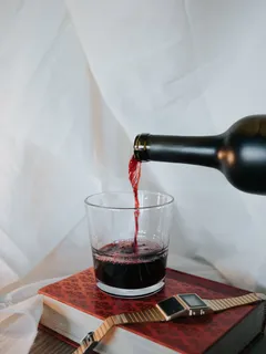 Číra pohár so sýto červenou tekutinou na bielom pozadí